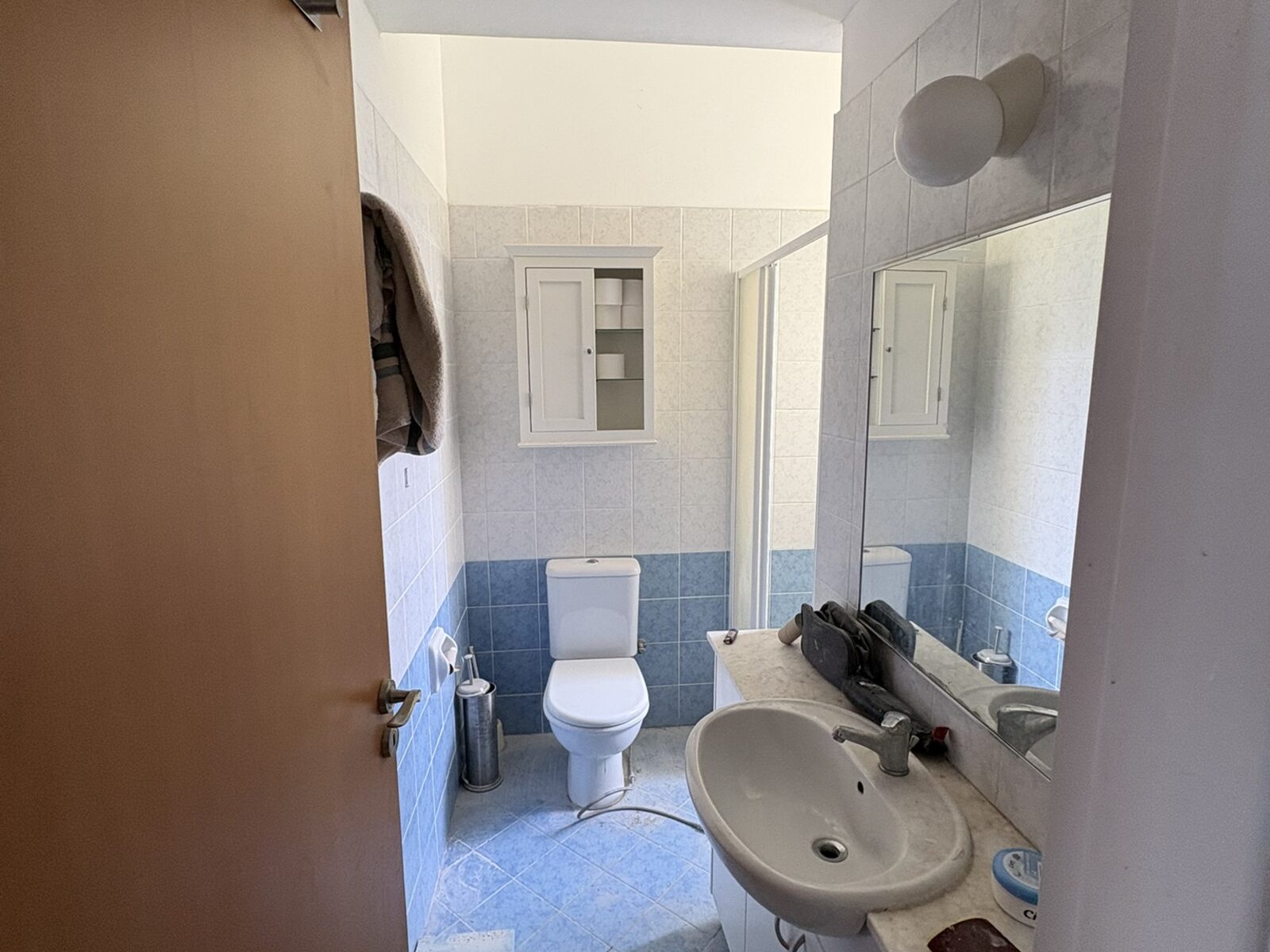 Pervolia bathroom before renovation, dated blue tiles